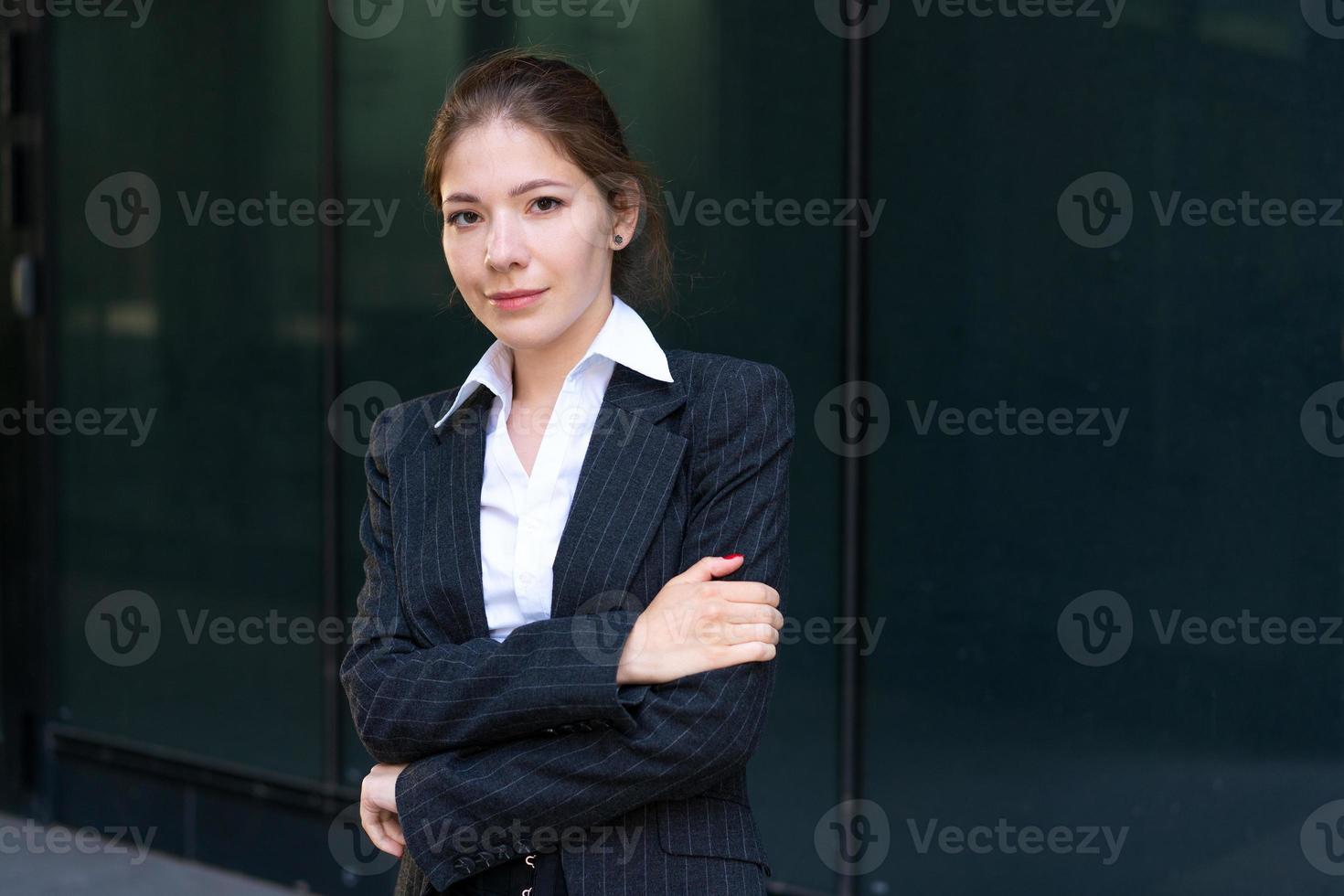 jovem mulher de negócios de terno perto do prédio de escritórios foto