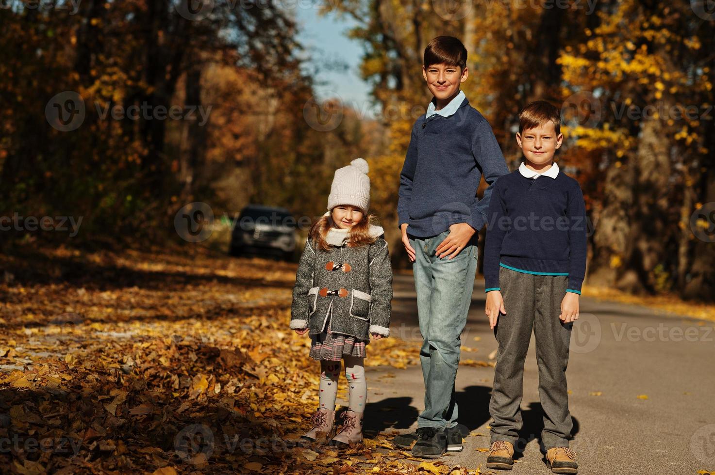 três crianças posando no parque outono outono. foto