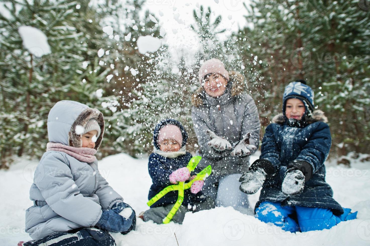 mãe com três filhos na natureza do inverno. ao ar livre na neve. foto