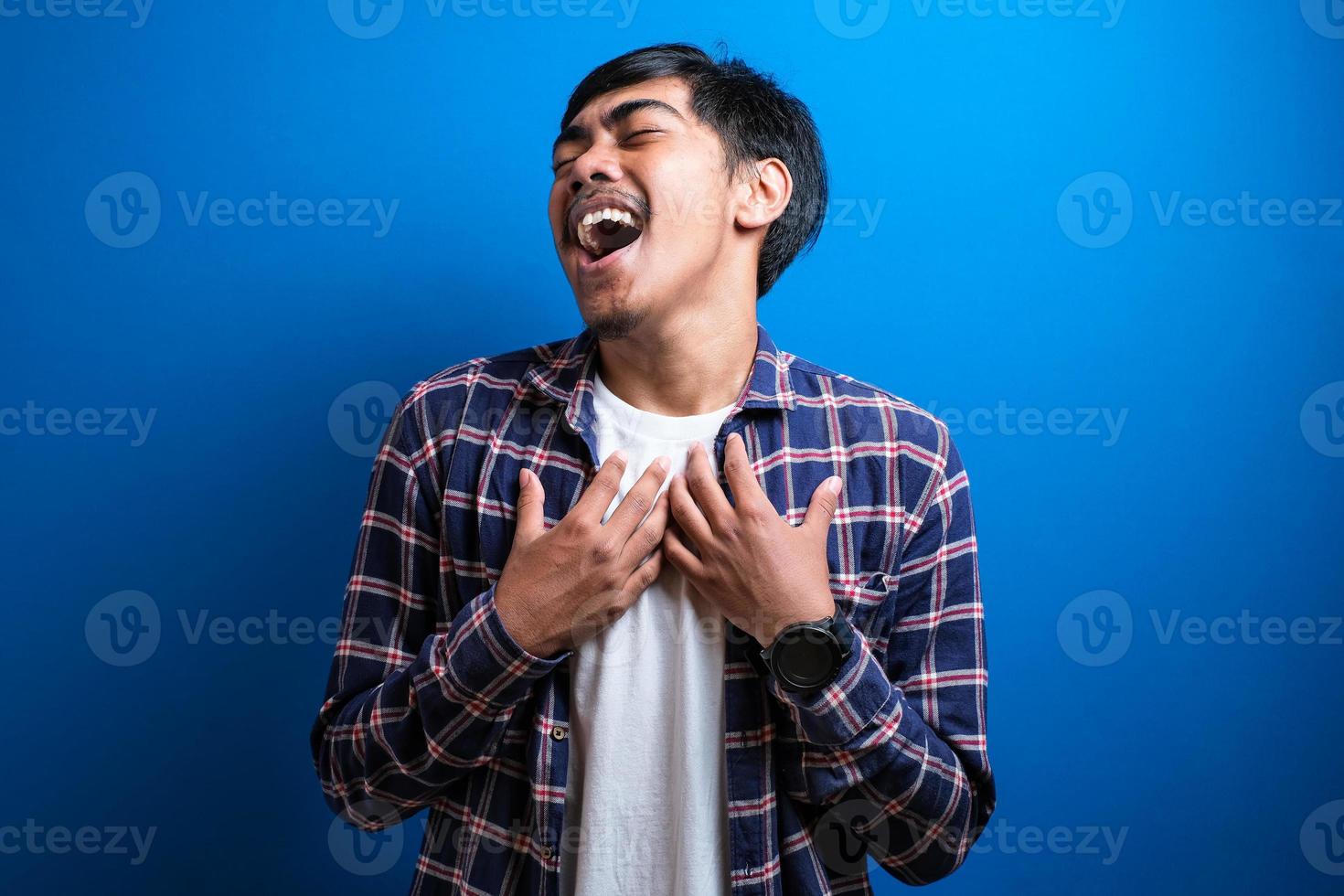 sorrisos de homem asiático feliz olhou para a câmera contra o fundo azul foto