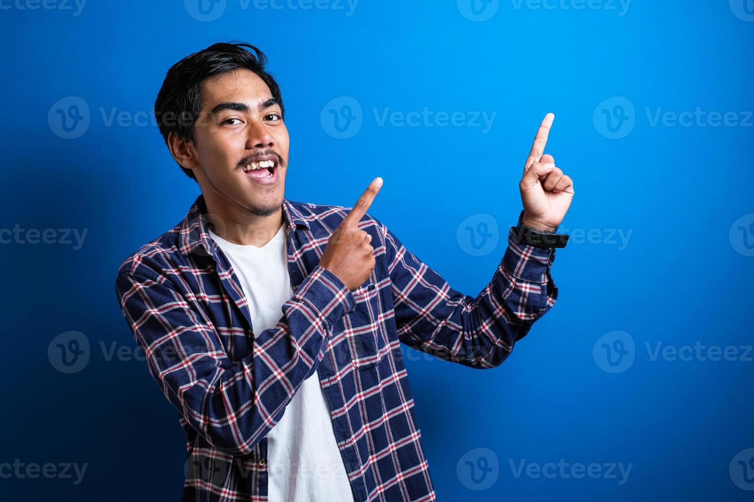 sorrisos de homem asiático feliz olhou para a câmera contra o fundo azul foto