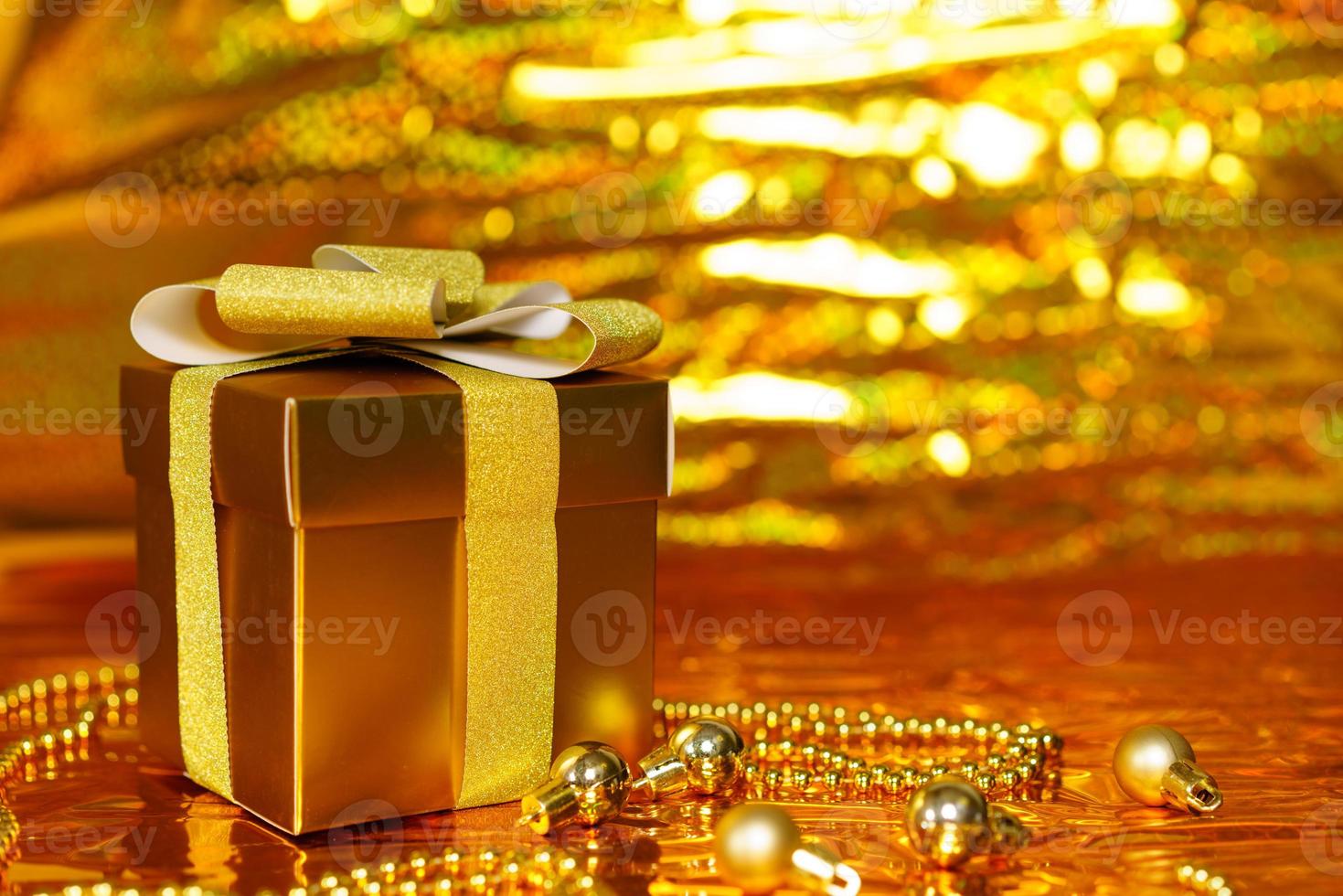 caixa de presente dourada em fundo brilhante foto