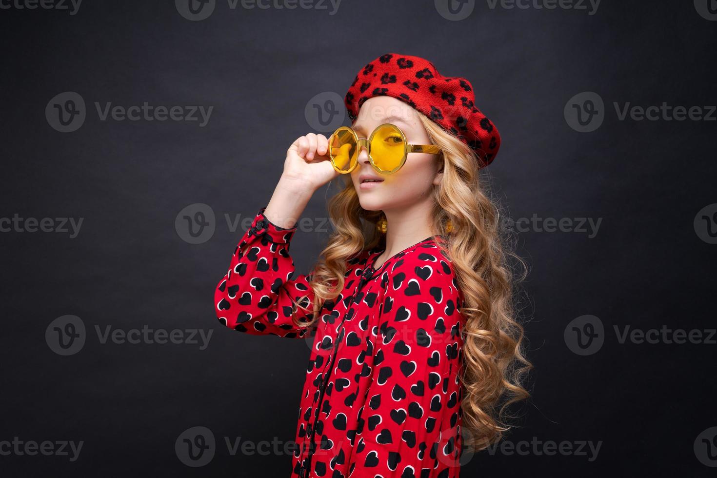 retrato menina de óculos amarelos em vestido vermelho com corações e boina vermelha foto