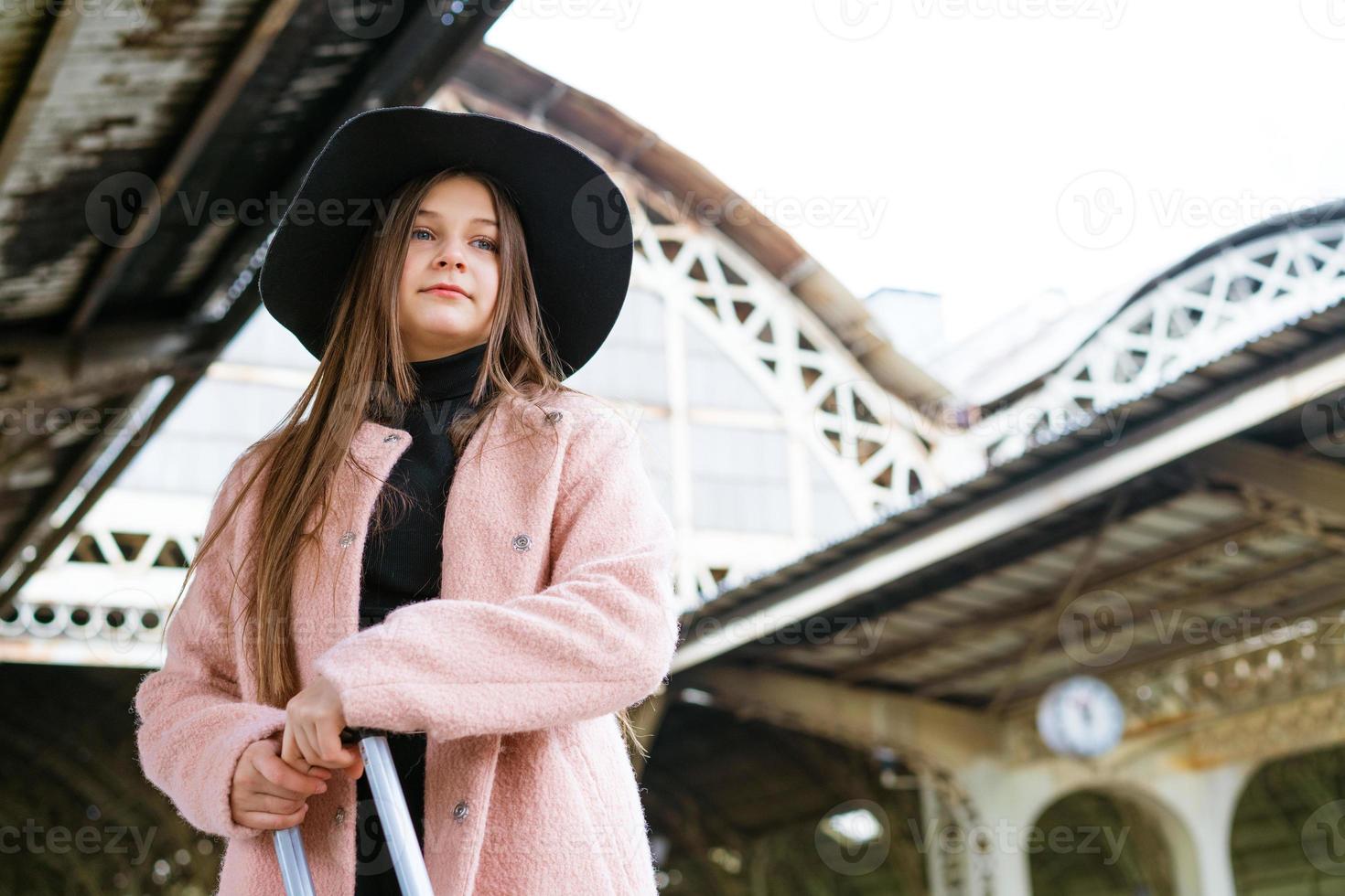 jovem com mala na plataforma da estação. garota viajante esperando foto