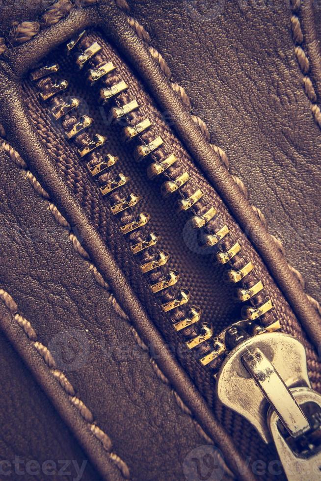 macro de um zíper aberto de bolsa de couro. estilo vintage. imagem vertical. foto