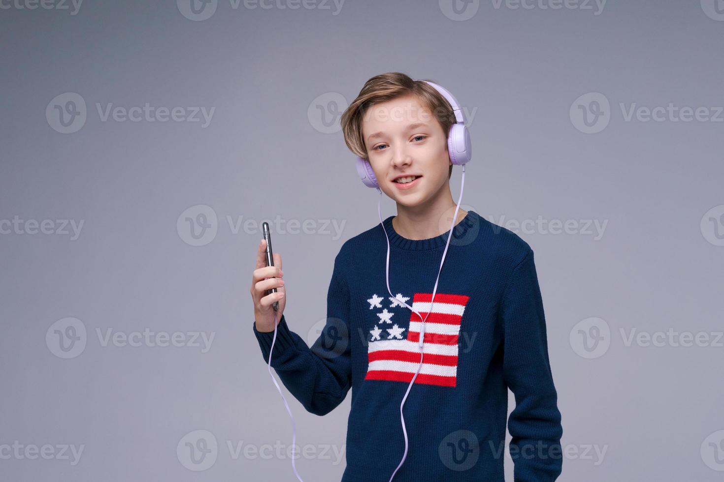 retrato jovem alegre de suéter azul com bandeira dos eua com fones de ouvido foto