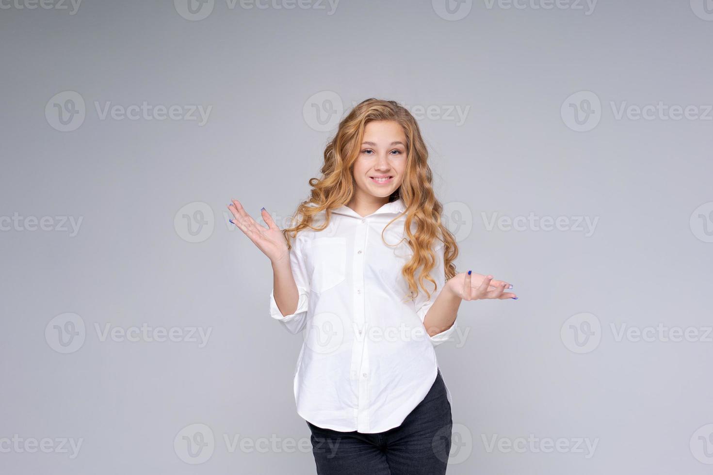 jovem mulher loira muito charmosa caucasiana com cabelos ondulados na camisa branca foto