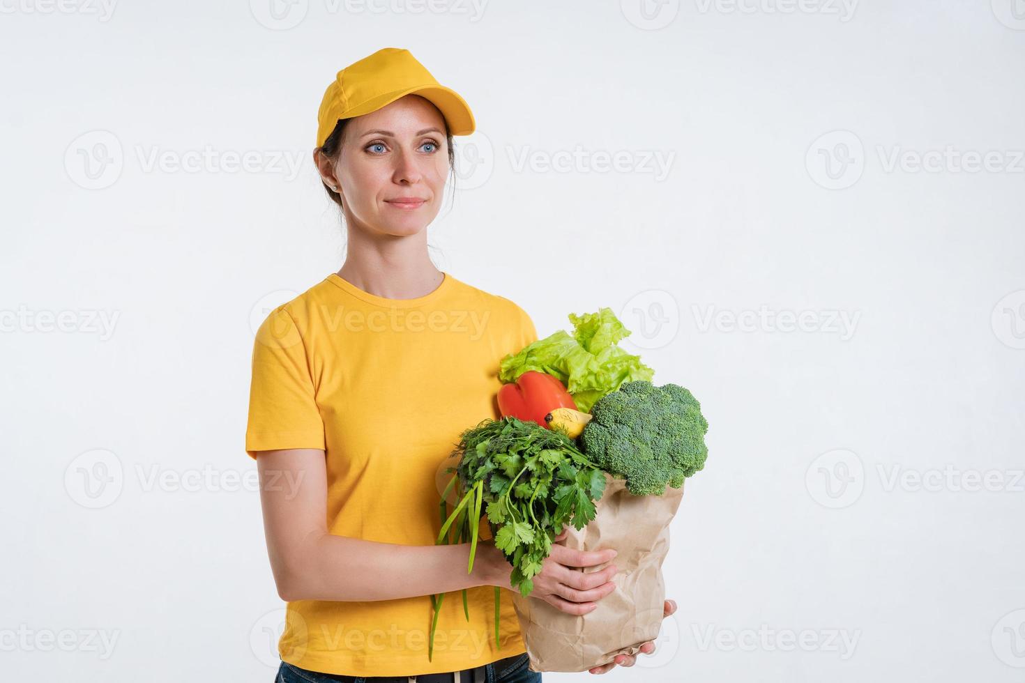 uma mulher com roupas amarelas, entregando um pacote de comida, em um fundo branco foto