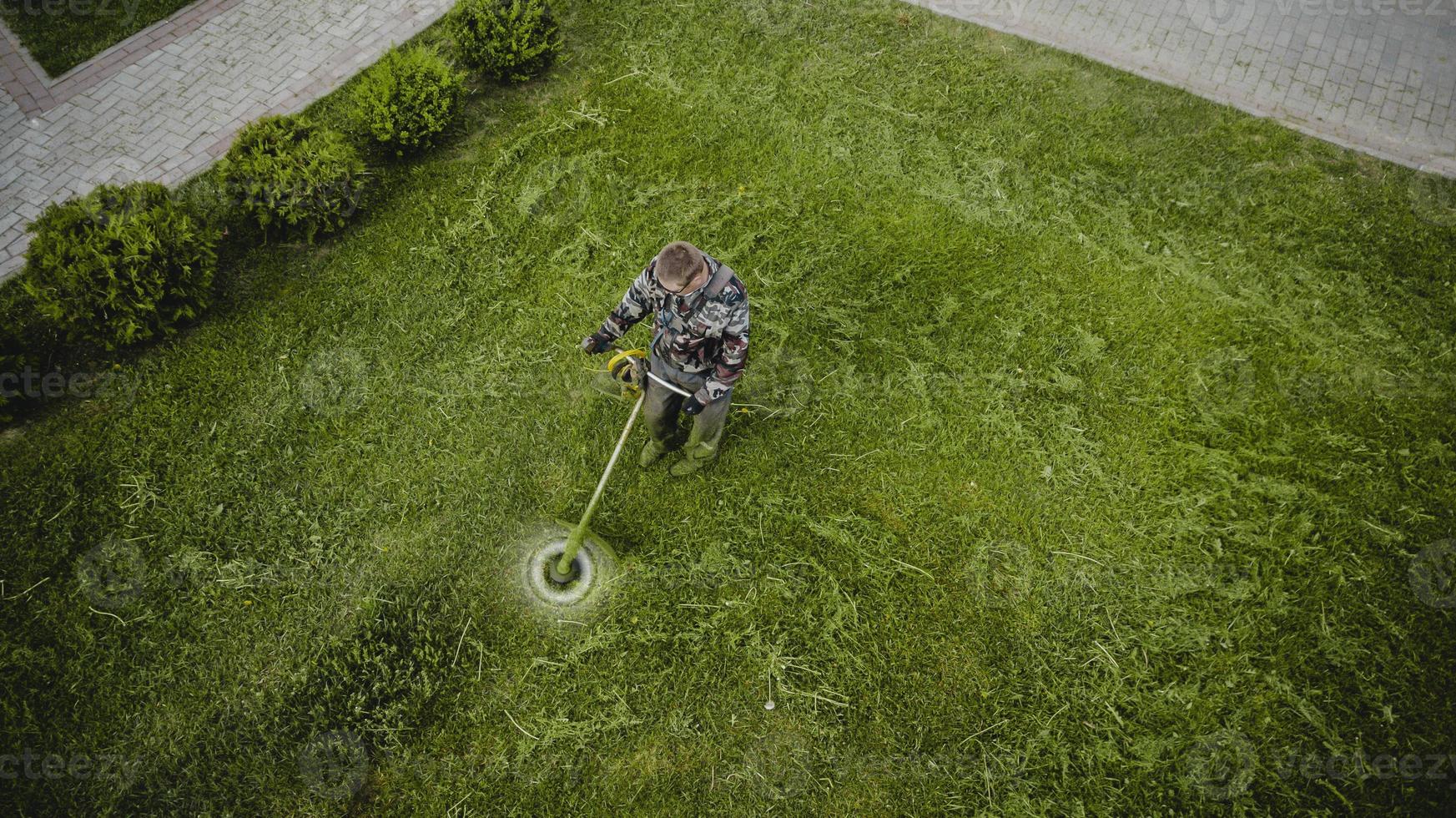 o homem do cortador de grama corta a grama a vista de cima foto