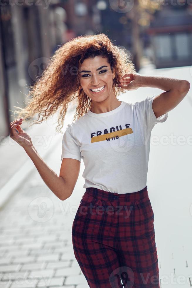 menina árabe sorridente em roupas casuais na rua. foto