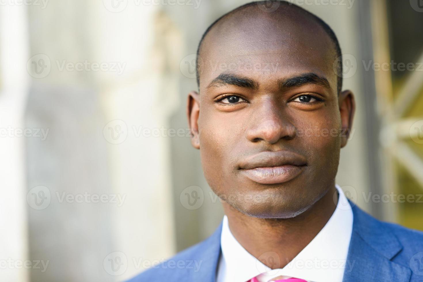 homem negro bonito vestindo terno em meio urbano foto