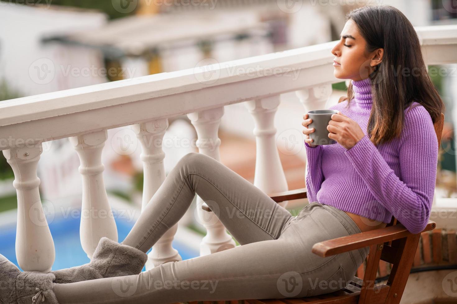 mulher persa na varanda dela tomando uma caneca de café foto