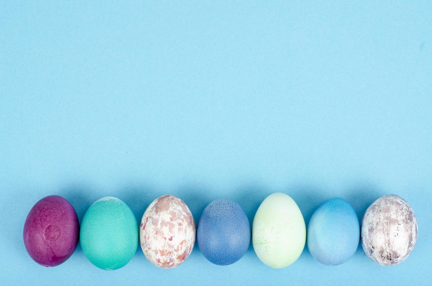 ovos de páscoa artesanais decorados para a temporada de férias em fundo azul. conceito abstrato mínimo criativo. foto de estúdio