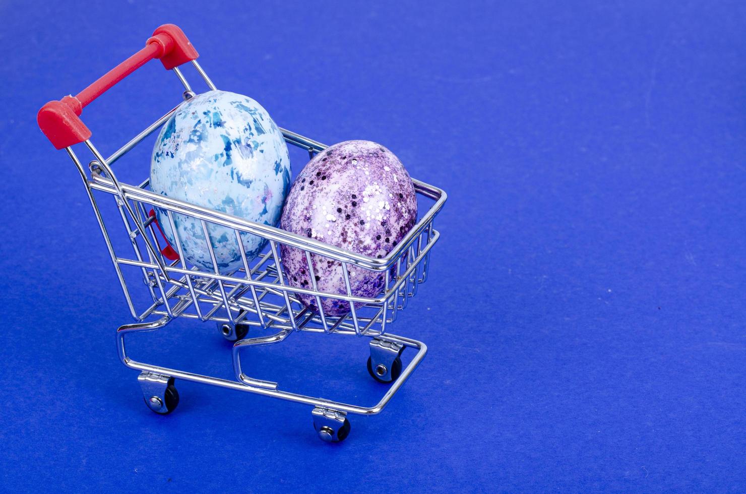 carrinho de supermercado cheio de ovos de galinha. conceito de preparação para a páscoa, comprando comida. espaço para texto. foto de estúdio