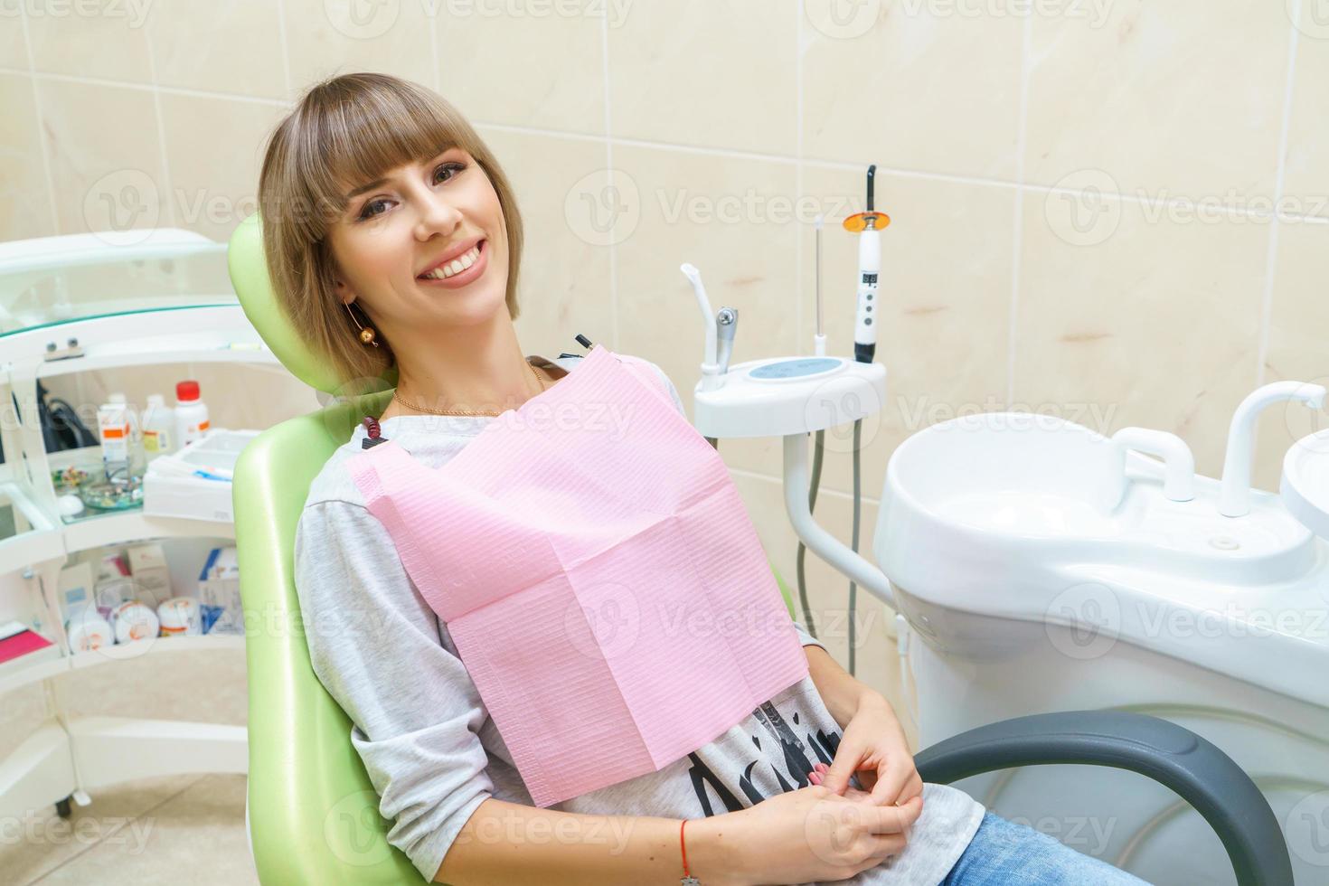 paciente sorridente feliz no consultório odontológico foto