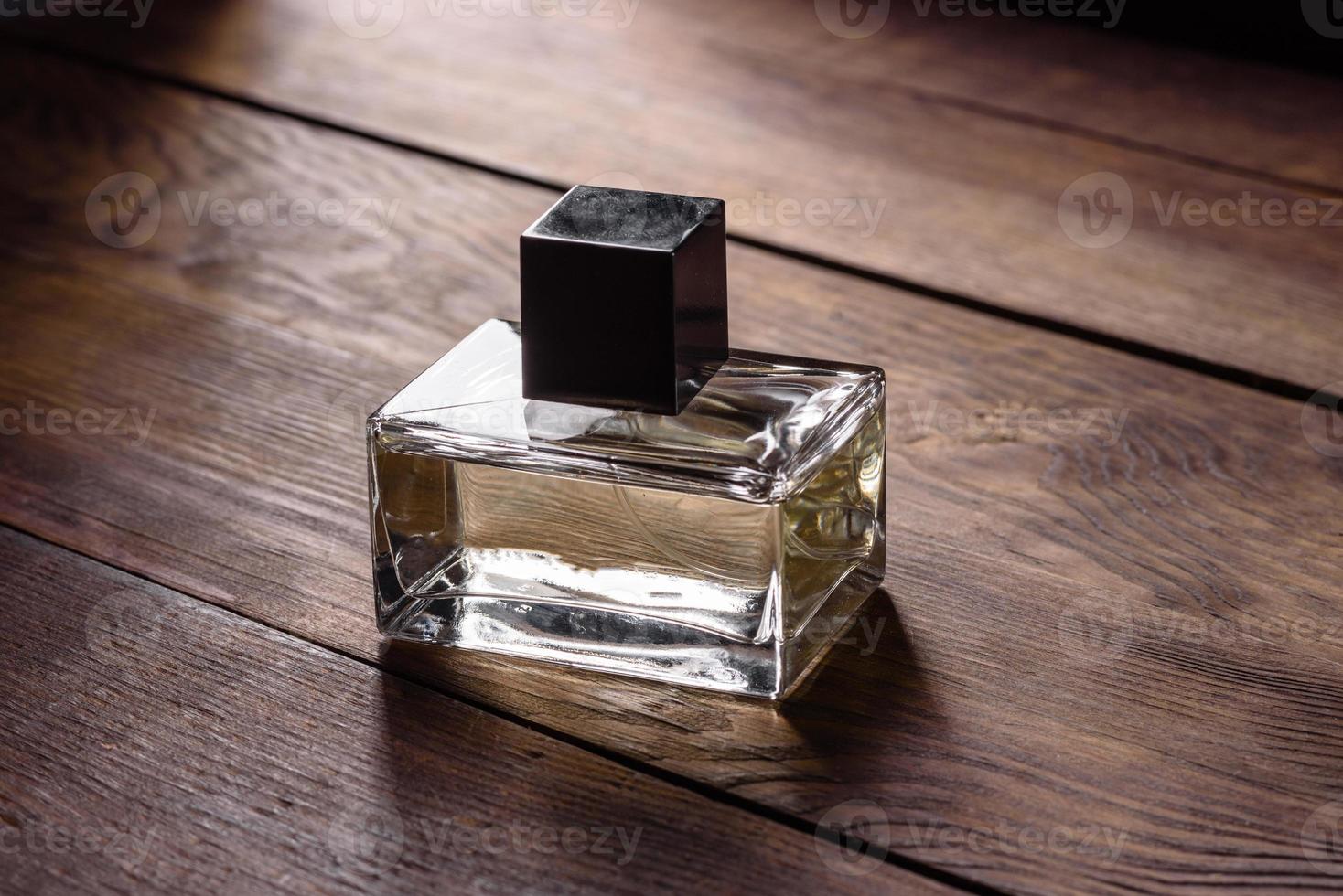frasco de perfume de vidro com raminho de alecrim no pódio de madeira foto