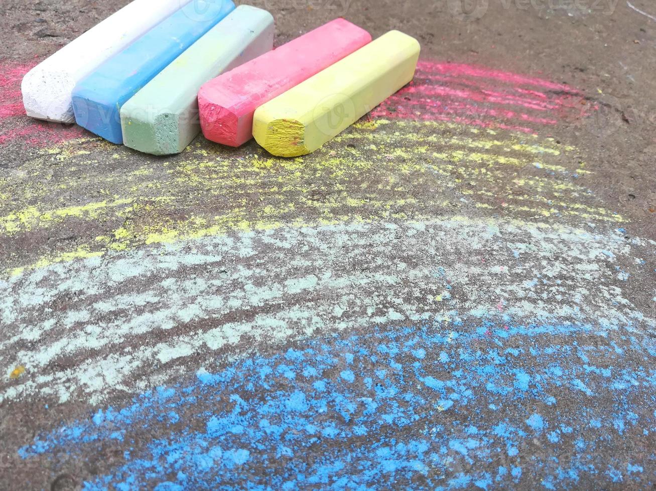 arco-íris é desenhado com giz no asfalto. fundo de verão colorido. desenho de crianças, símbolo lgbt foto