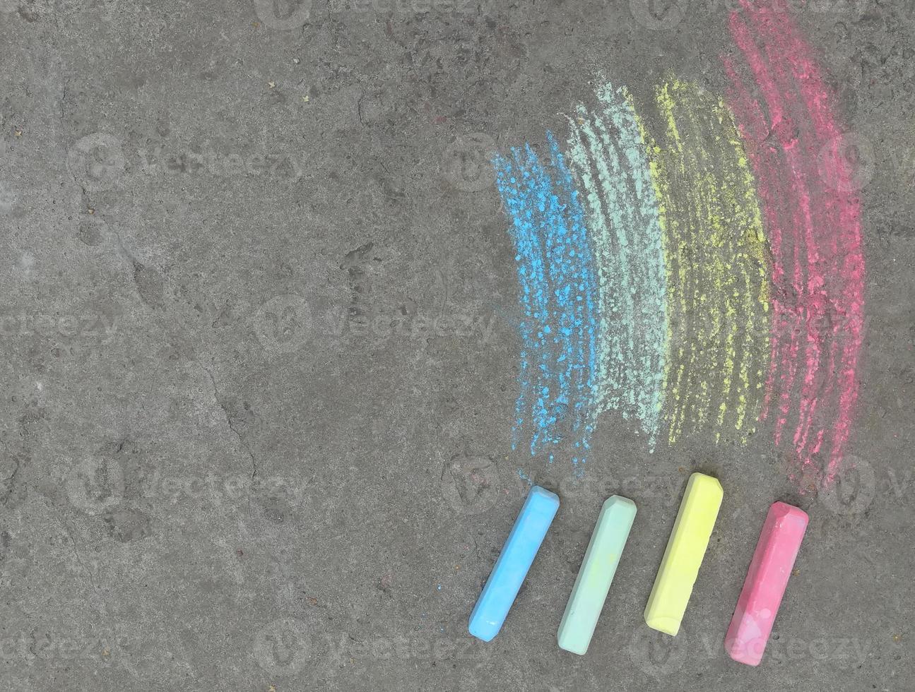 arco-íris é desenhado com giz no asfalto. fundo de verão colorido. desenho de crianças, espaço de cópia de símbolo lgbt, lugar para texto foto