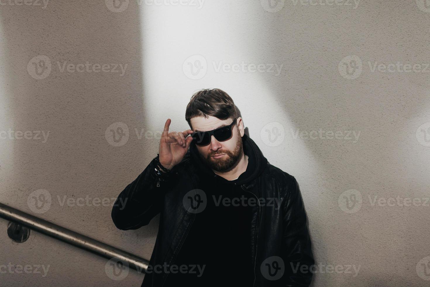 bonito modelo masculino com barba vestindo jaqueta preta foto