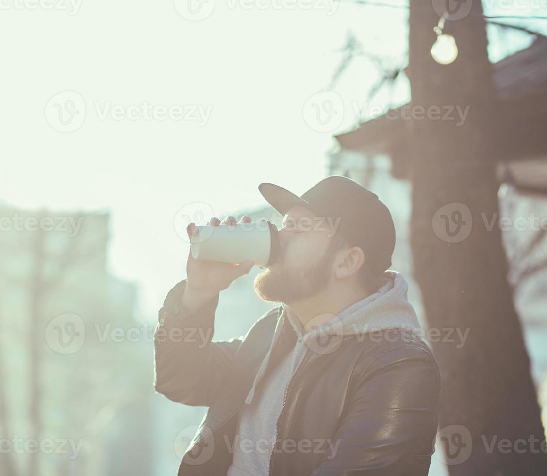 homem em uma jaqueta de couro tomando café foto