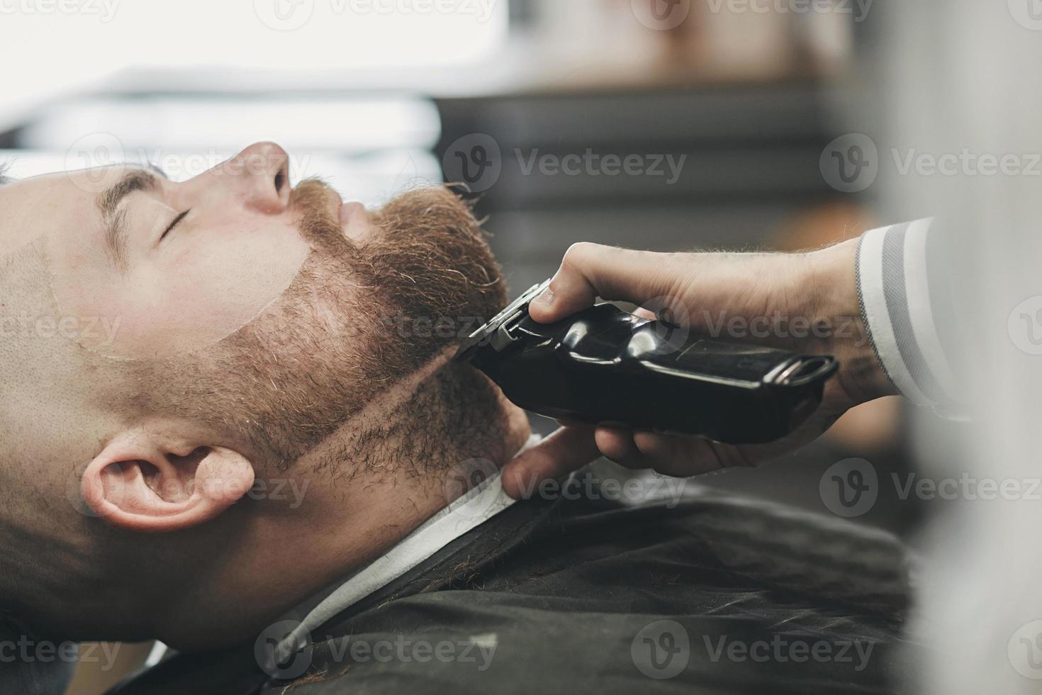 mestre corta a barba de um cara foto