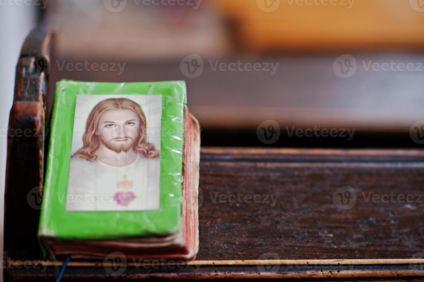 livro de orações com jesus cristo na capa no banco na igreja foto