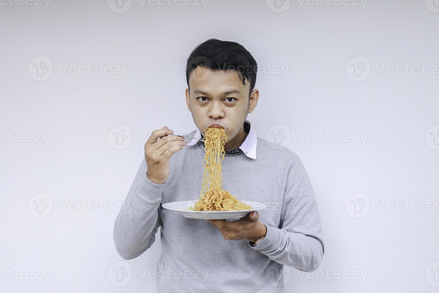 jovem asiático gosta de macarrão. comendo o conceito de almoço. foto