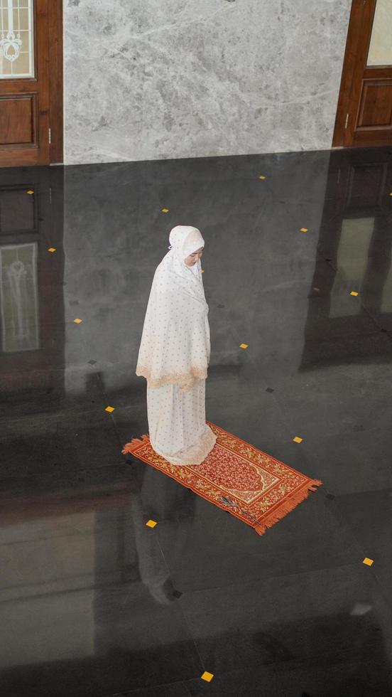 mulher muçulmana asiática rezando sozinha sem imã na mesquita foto