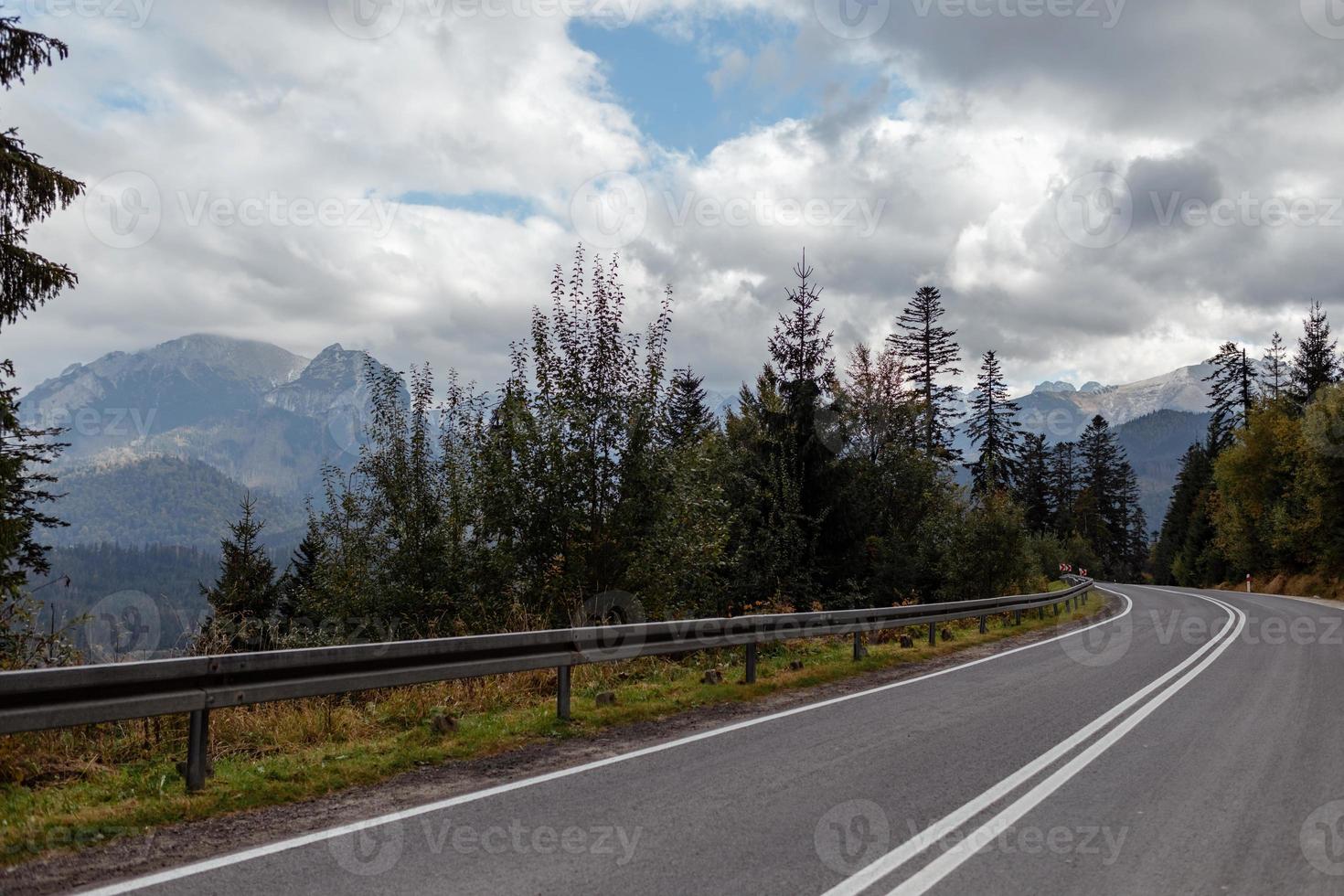 paisagem de outono inverno, montanha desaparecendo no dia nublado de neblina e uma estrada de asfalto foto