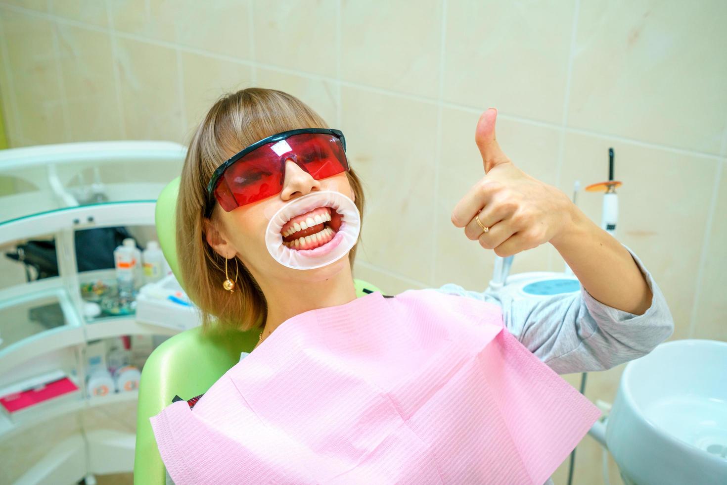 odontologia paciente feliz na cadeira em óculos foto