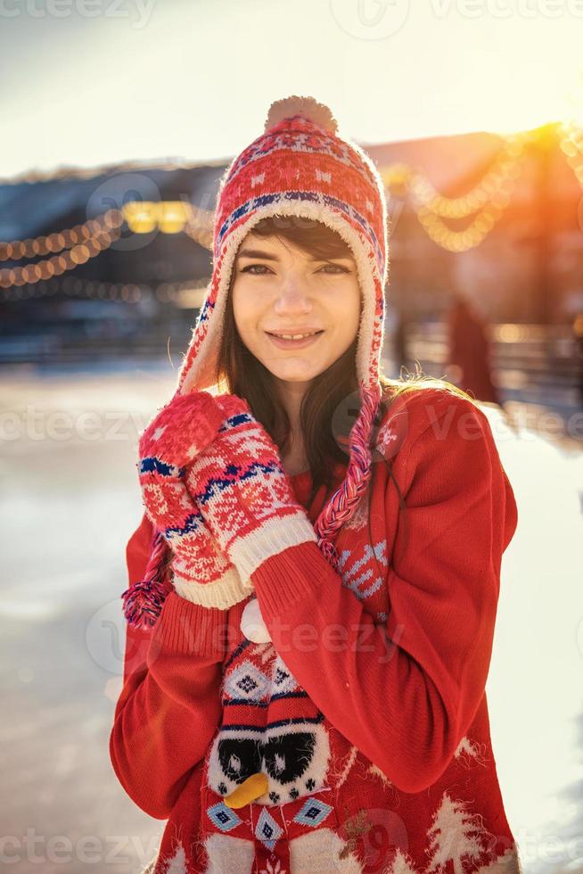retrato de uma jovem na pista de gelo, um sorriso no rosto, o sol foto
