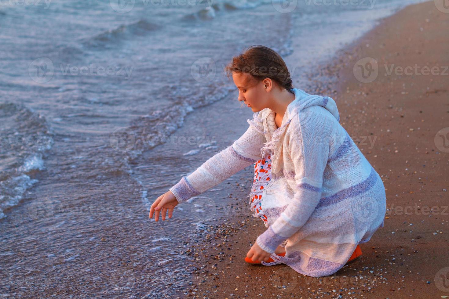 menina sentada na praia foto