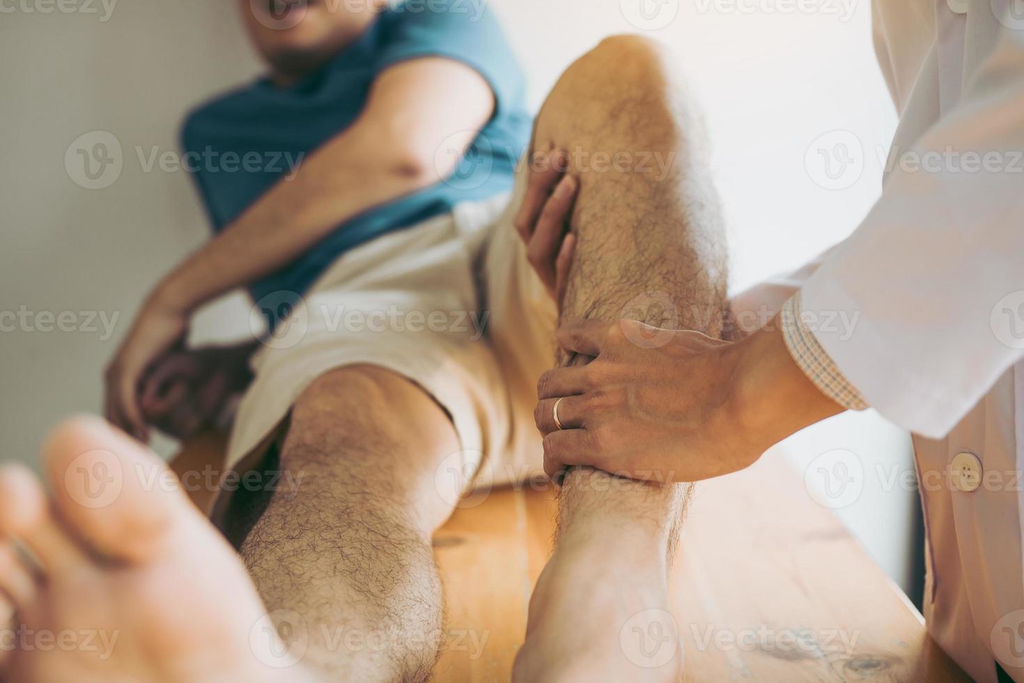 fisioterapeutas estão usando as mãos para pressionar as panturrilhas do paciente para verificar a dor e massagear na clínica. foto