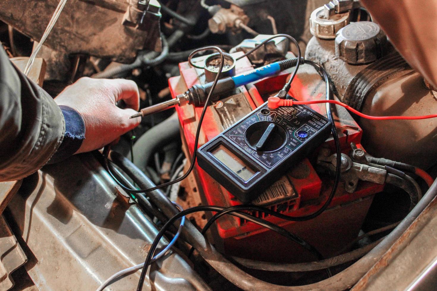 o processo de reparação de eletrônicos em um carro. usando um multímetro. teste de quebra de fio foto