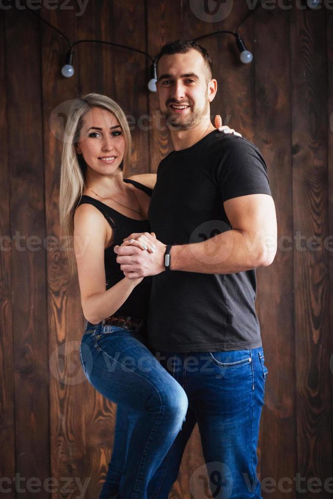 jovem casal dançando música latina bachata, merengue, salsa. duas poses de elegância no café com paredes de tijolos foto