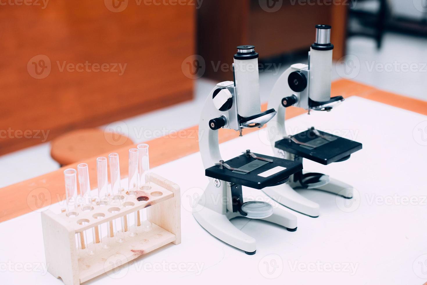 microscópio de metal de laboratório e tubos de ensaio vazios na mesa. dia nacional da ciência, dia mundial da ciência foto