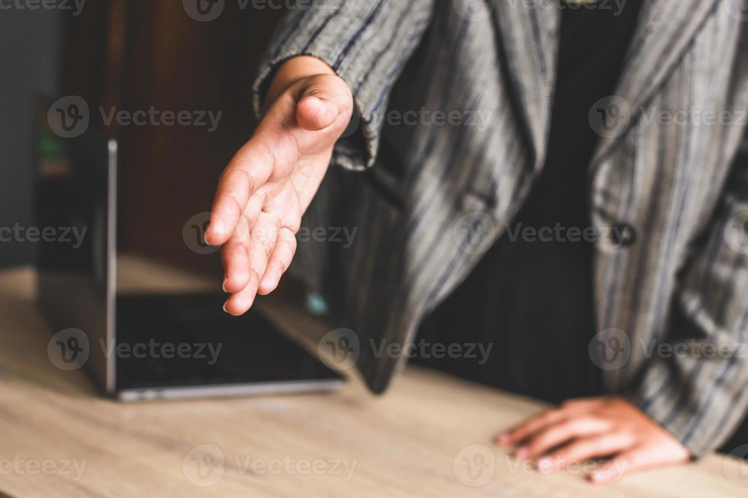 mulher de negócios em pé e dá a mão para o aperto de mão propõe parceria, negócios de sucesso, saudação foto