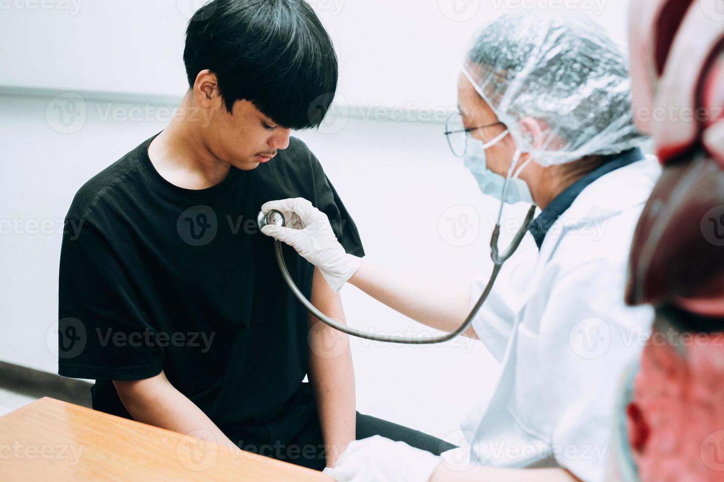 médico com estetoscópio ouve coração e pulmões do paciente foto