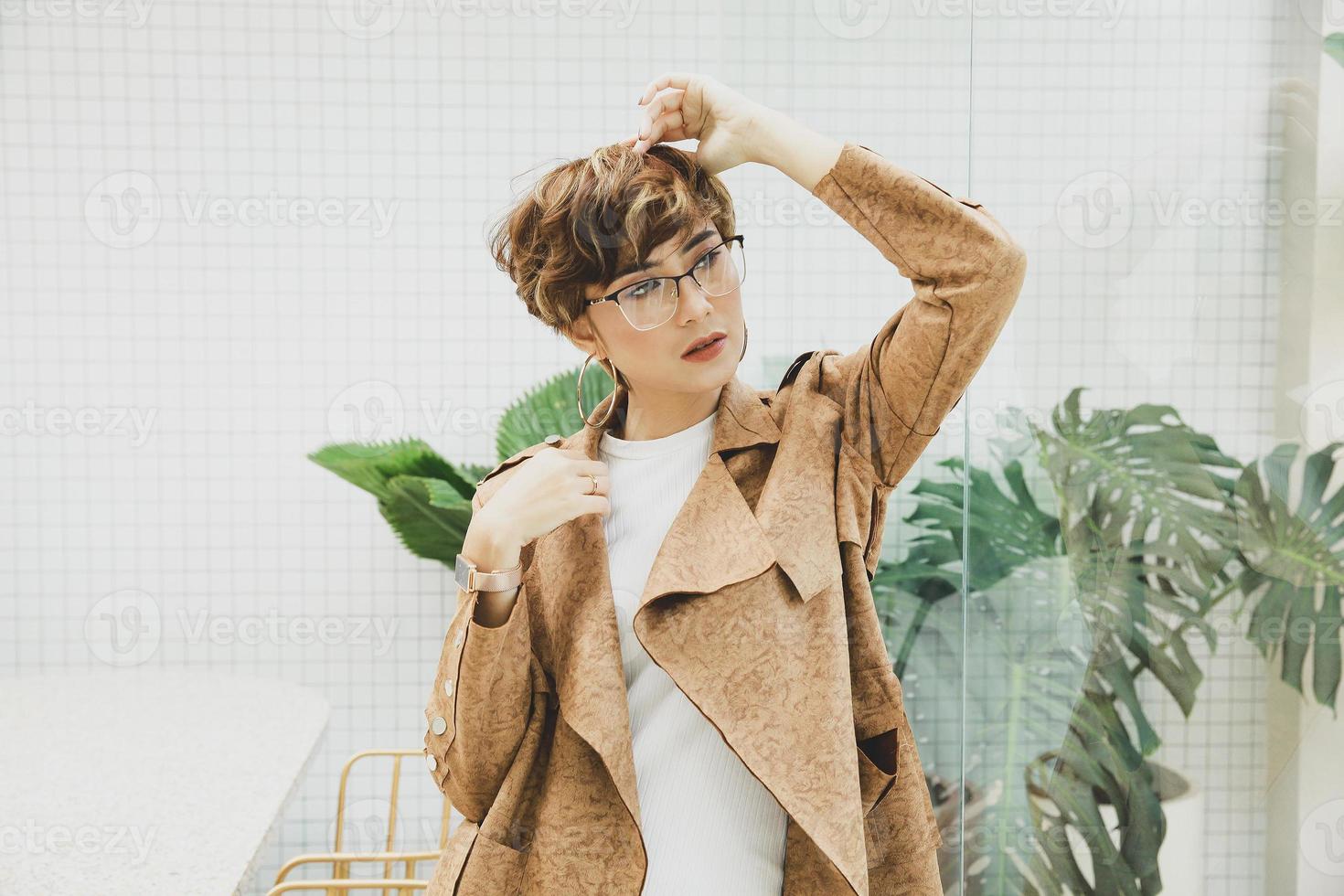 loira linda mulher asiática usando óculos e casaco marrom foto