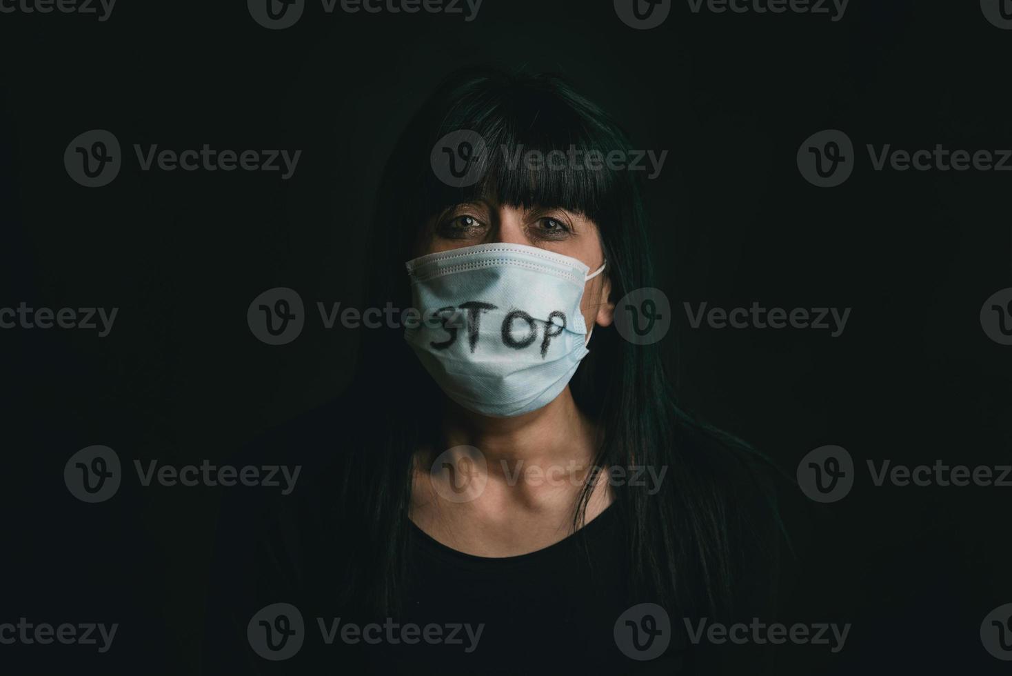 pare a violência, mulher assustada usando máscara médica para coronavírus vítima de violência doméstica foto