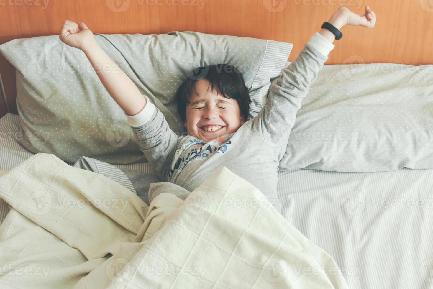 menino esticando na cama foto