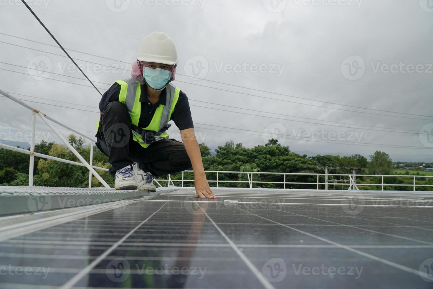 mulher de energia trabalhando em um telhado com painéis solares. foto