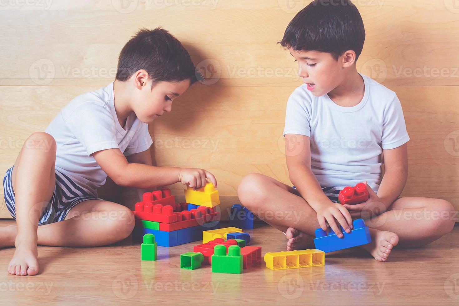 irmãos brincando com blocos coloridos foto