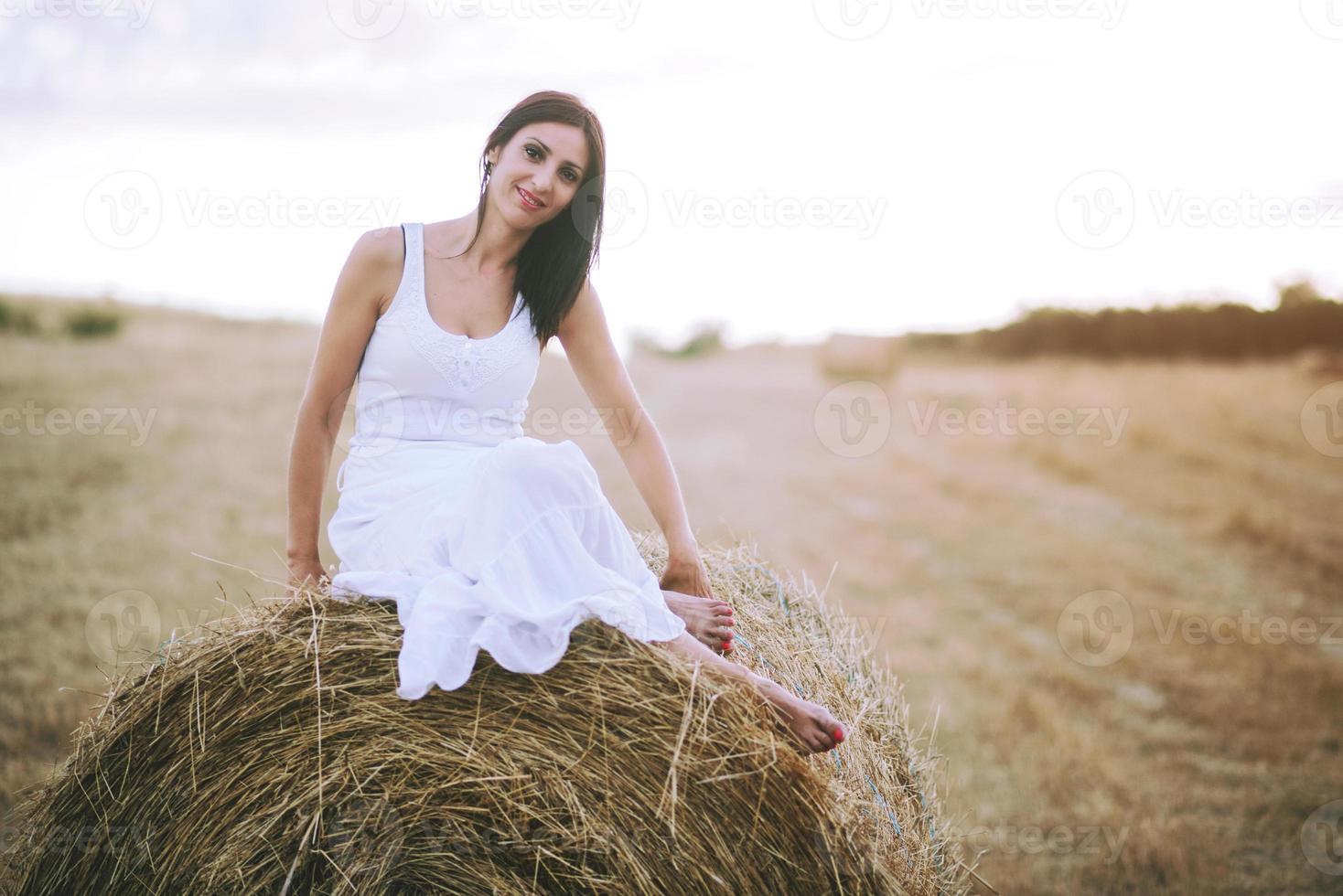 menina sorridente sentada na palha foto