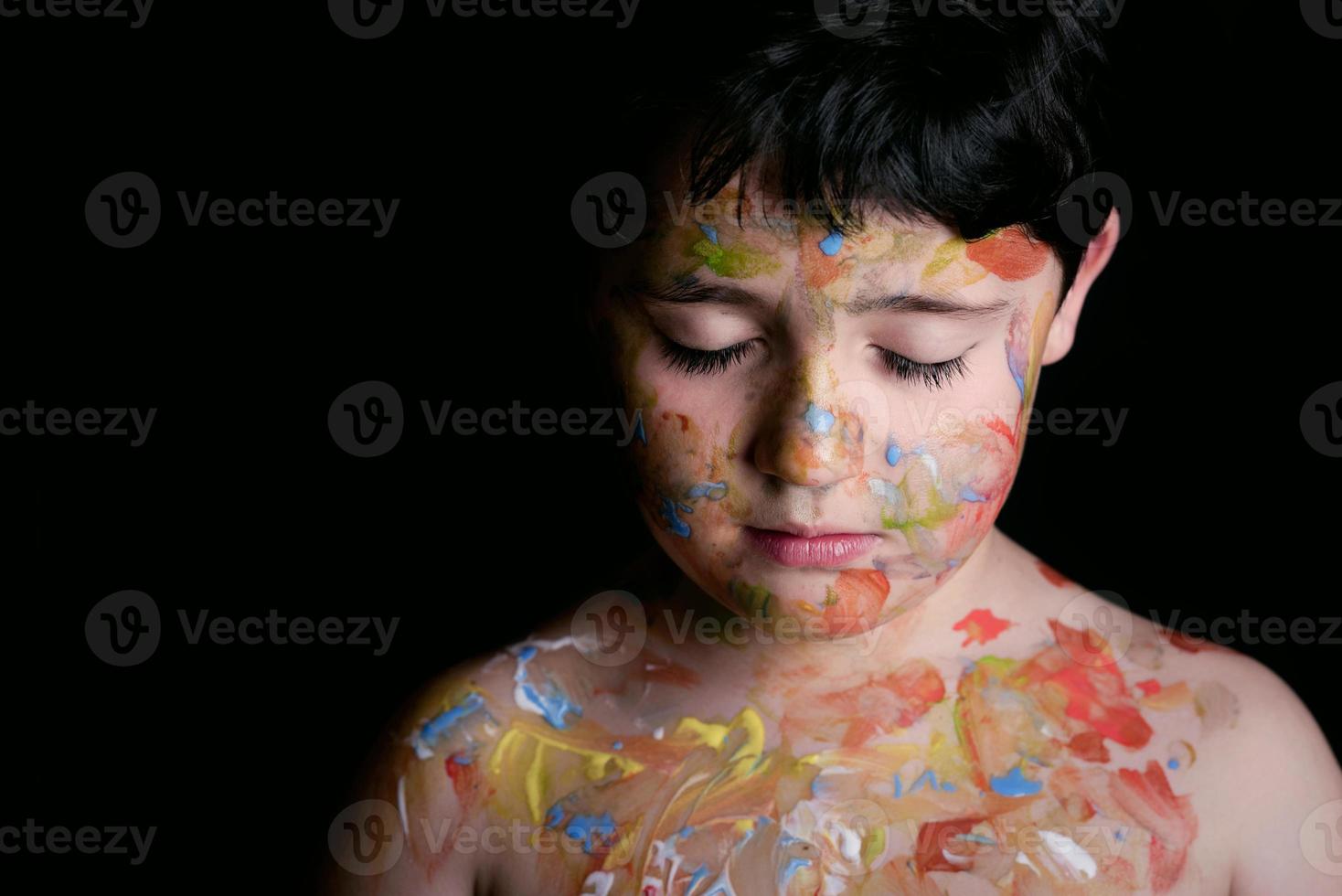 menino com pintura de rosto em fundo preto foto