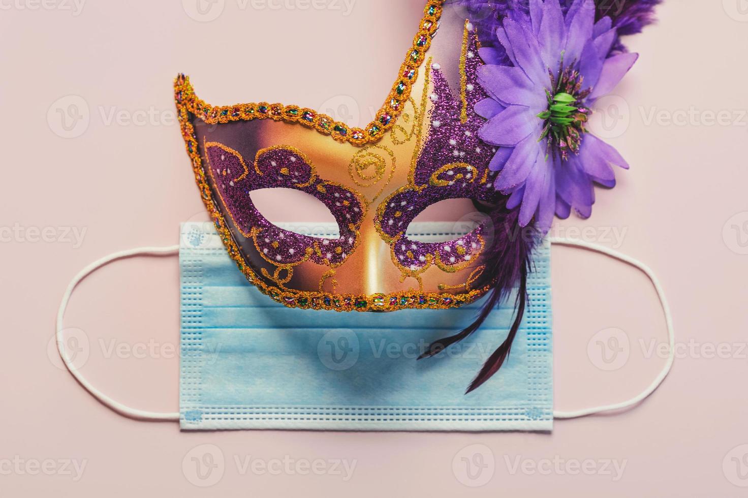 conceito de carnaval durante o covid-19. máscara de carnaval veneziano com máscara cirúrgica protetora. conceito de celebração de carnaval foto