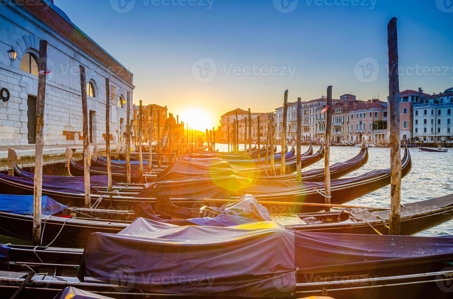 gôndolas ancoradas no cais da via navegável do grande canal em veneza foto