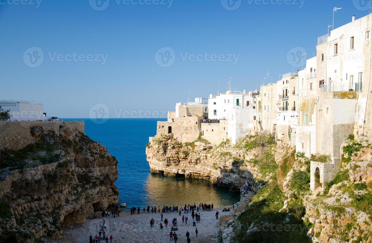 vista da praia lama monachile cala porto e edifícios brancos em grutas e falésias na cidade de polignano a mare foto