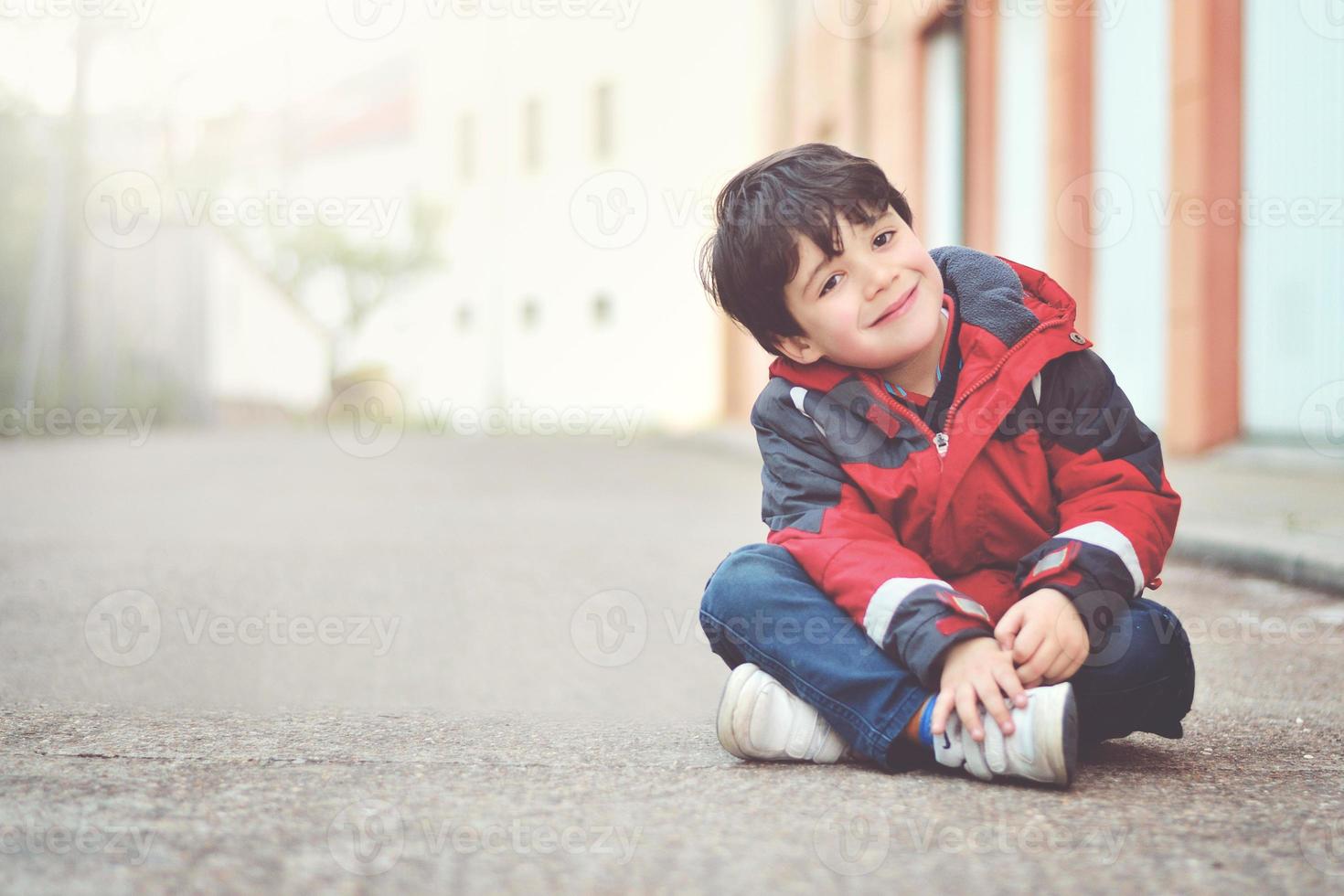 menino feliz sentado no chão foto
