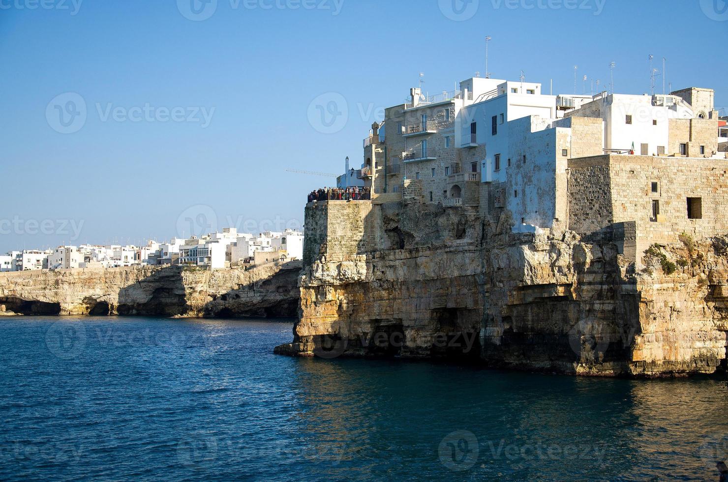 edifícios brancos em grutas e falésias na cidade de polignano uma égua em puglia foto